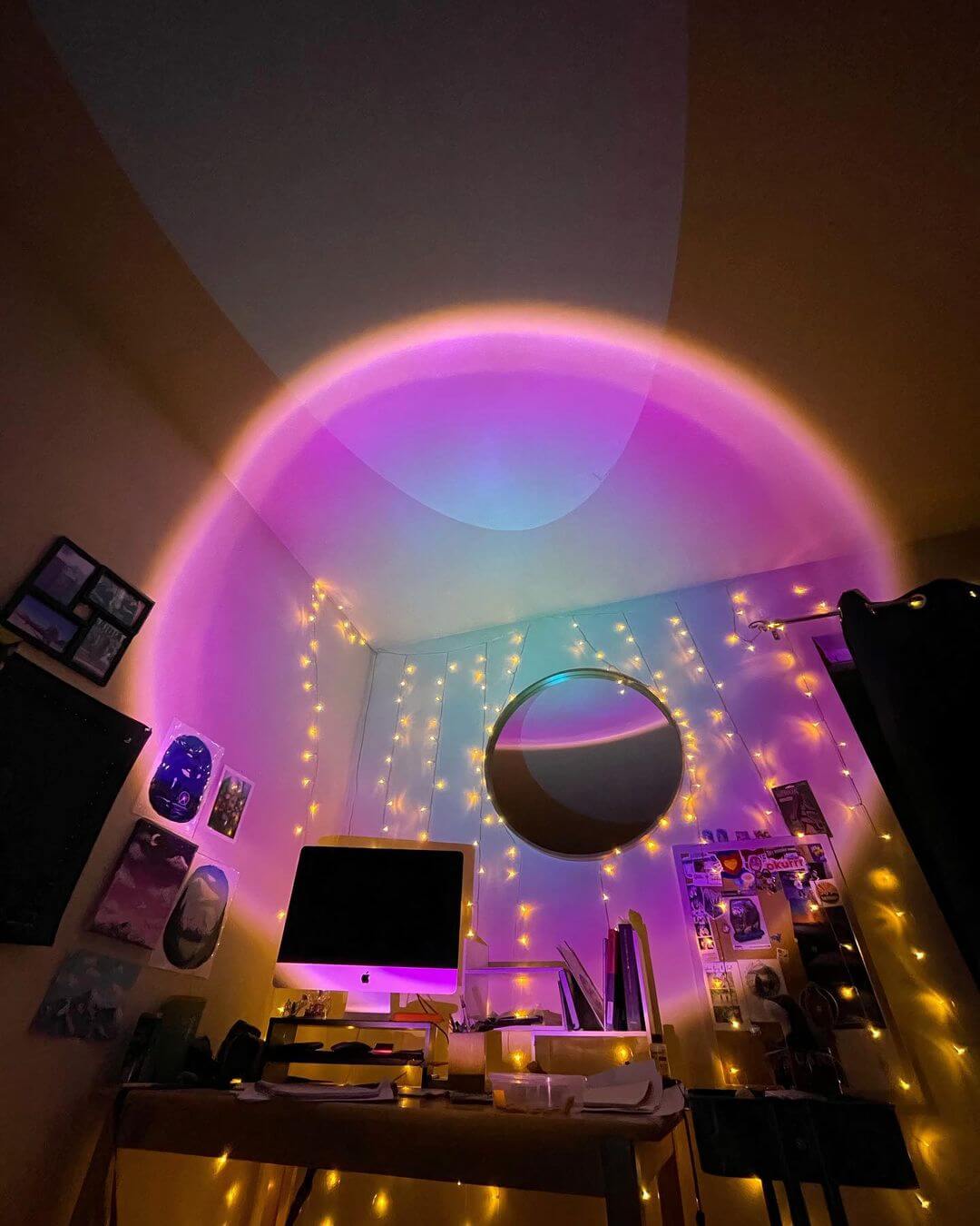 Colorful sunset lamp projecting a large gradient circle of pink, purple, and blue hues onto a bedroom wall, creating a dreamy and vibrant lighting effect.